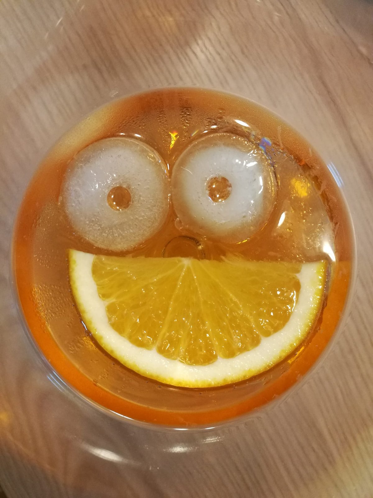Aperol Spritz mit lachendem Gesicht aus Eis und Orange
